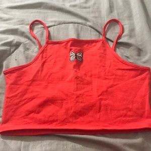 A simple red crop top with a butterfly in the middle of it. It is a size large